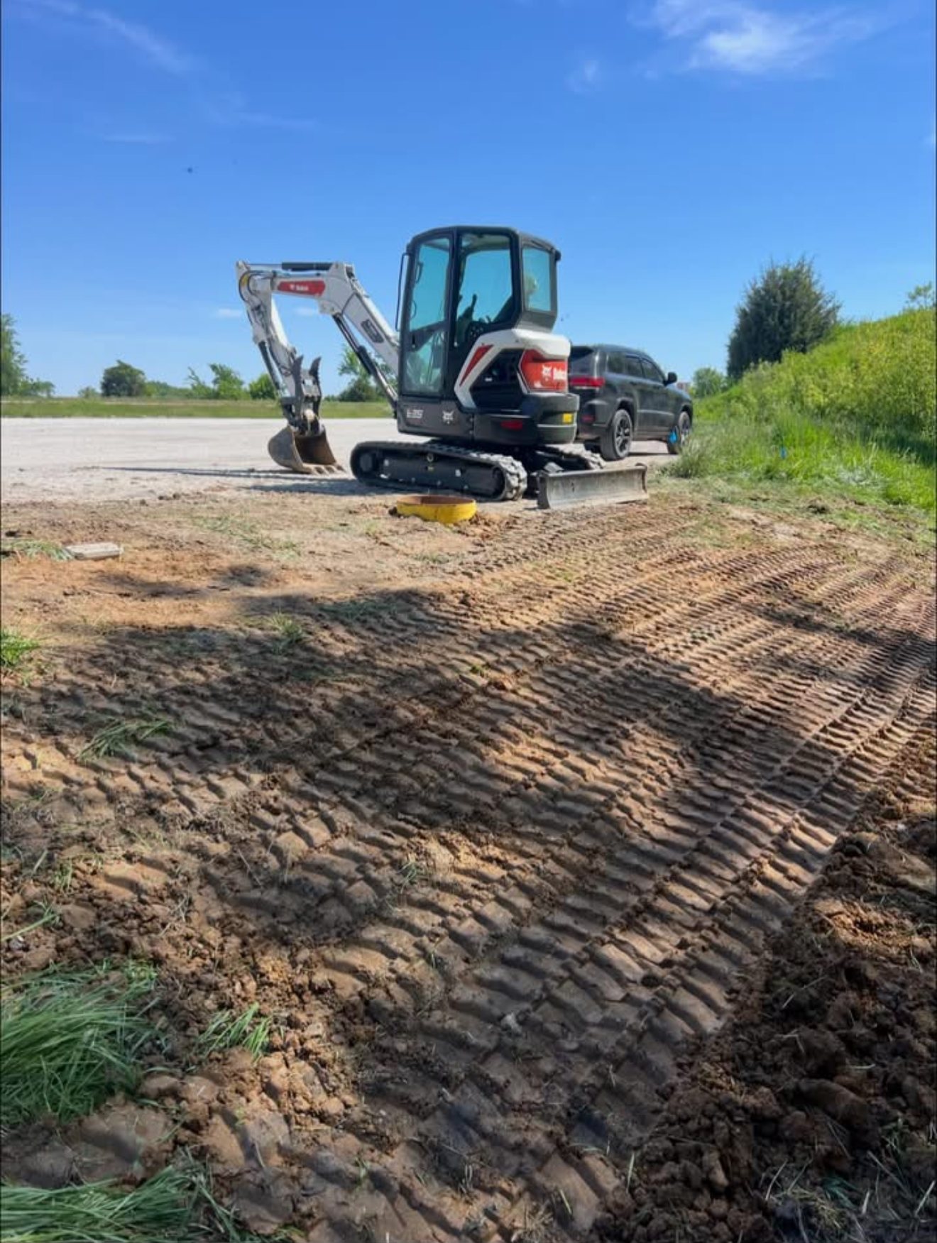 Thompson Excavating's compact excavator on a freshly graded job site