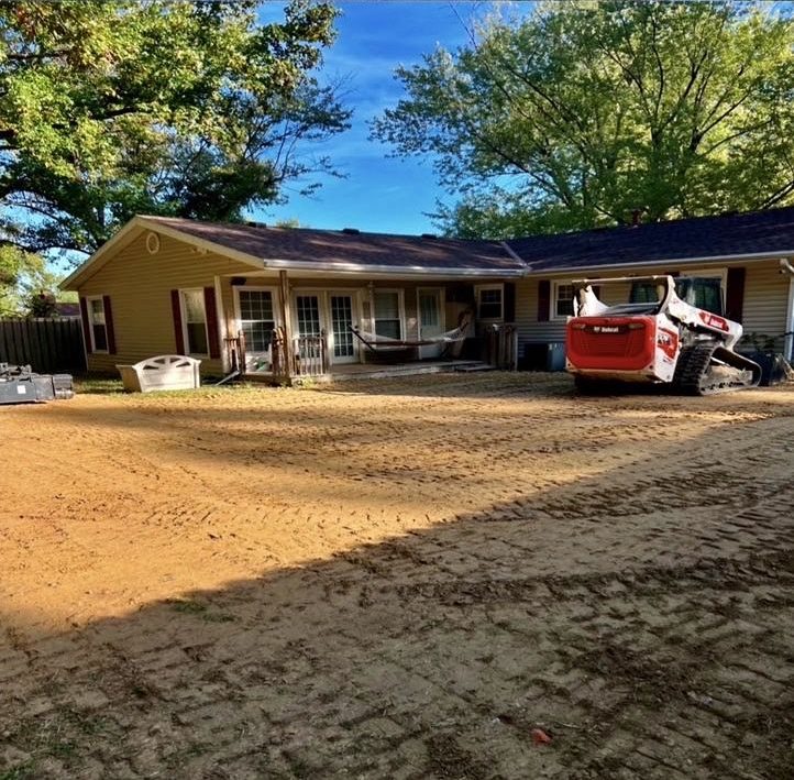 Bobcat track loader on a freshly graded backyard after an in-ground pool was removed